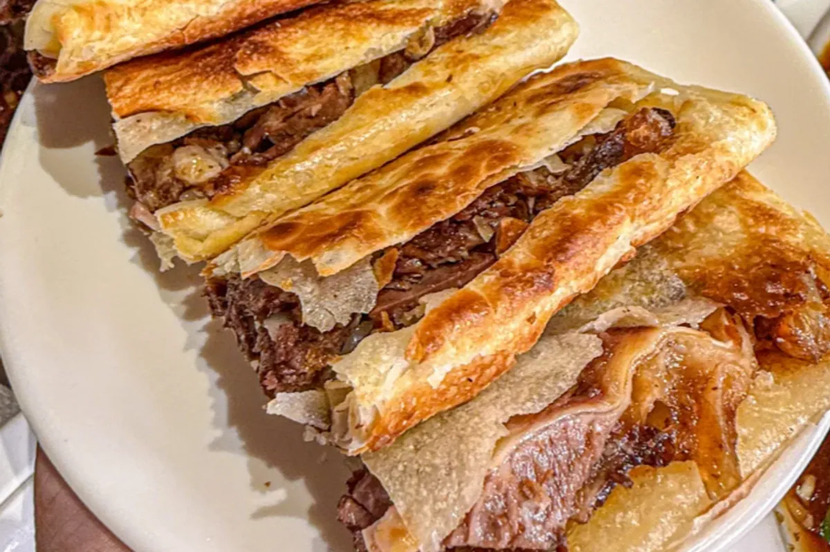 Donkey burger — shredded braised donkey meat stuffed into a crisp flaky flatbread