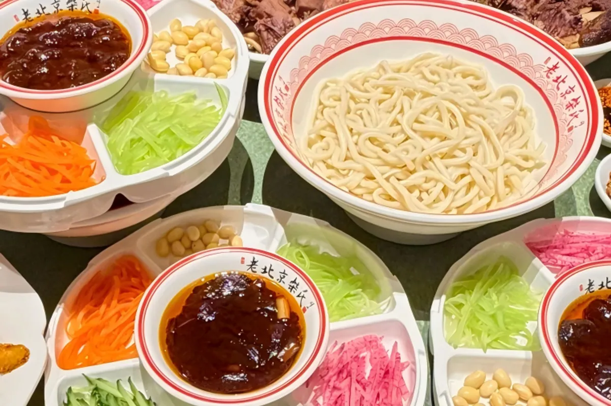 Zhajiangmian — thick wheat noodles topped with fermented soybean paste, pork, and fresh shredded vegetables
